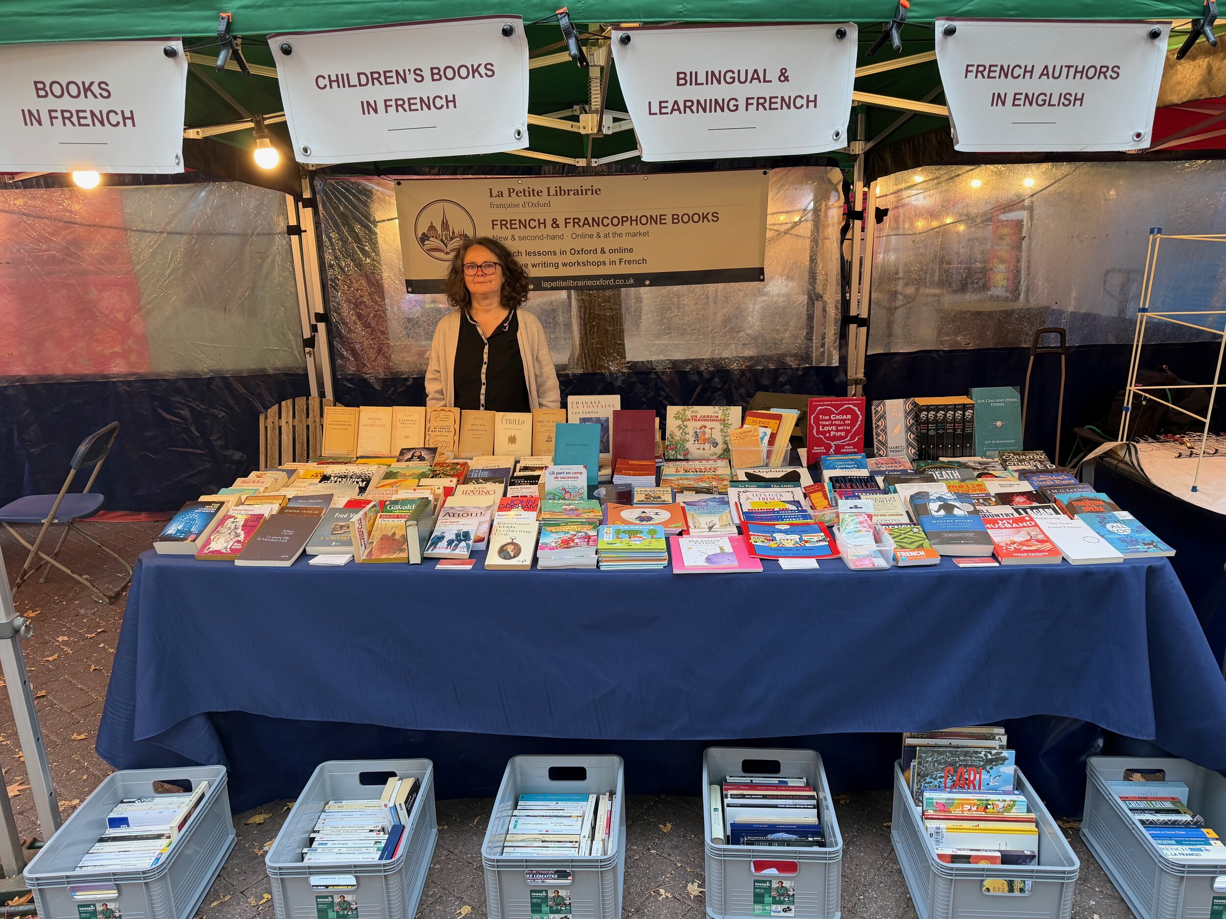 Olivia behind her French book stall at Gloucester Green Market in Oxford