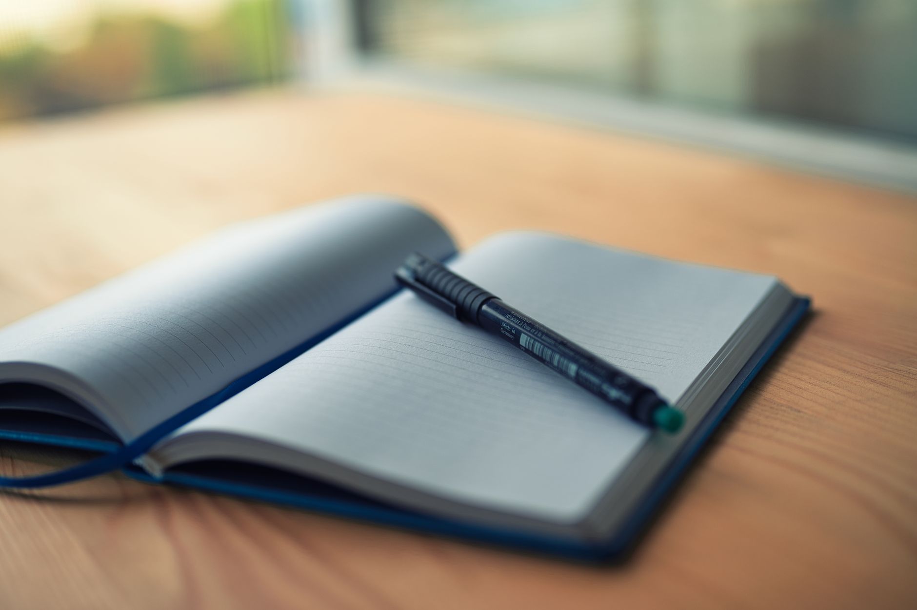 un cahier a lignes ouvert avec un stylo reposant sur un bureau en bois capturant un moment de creativite