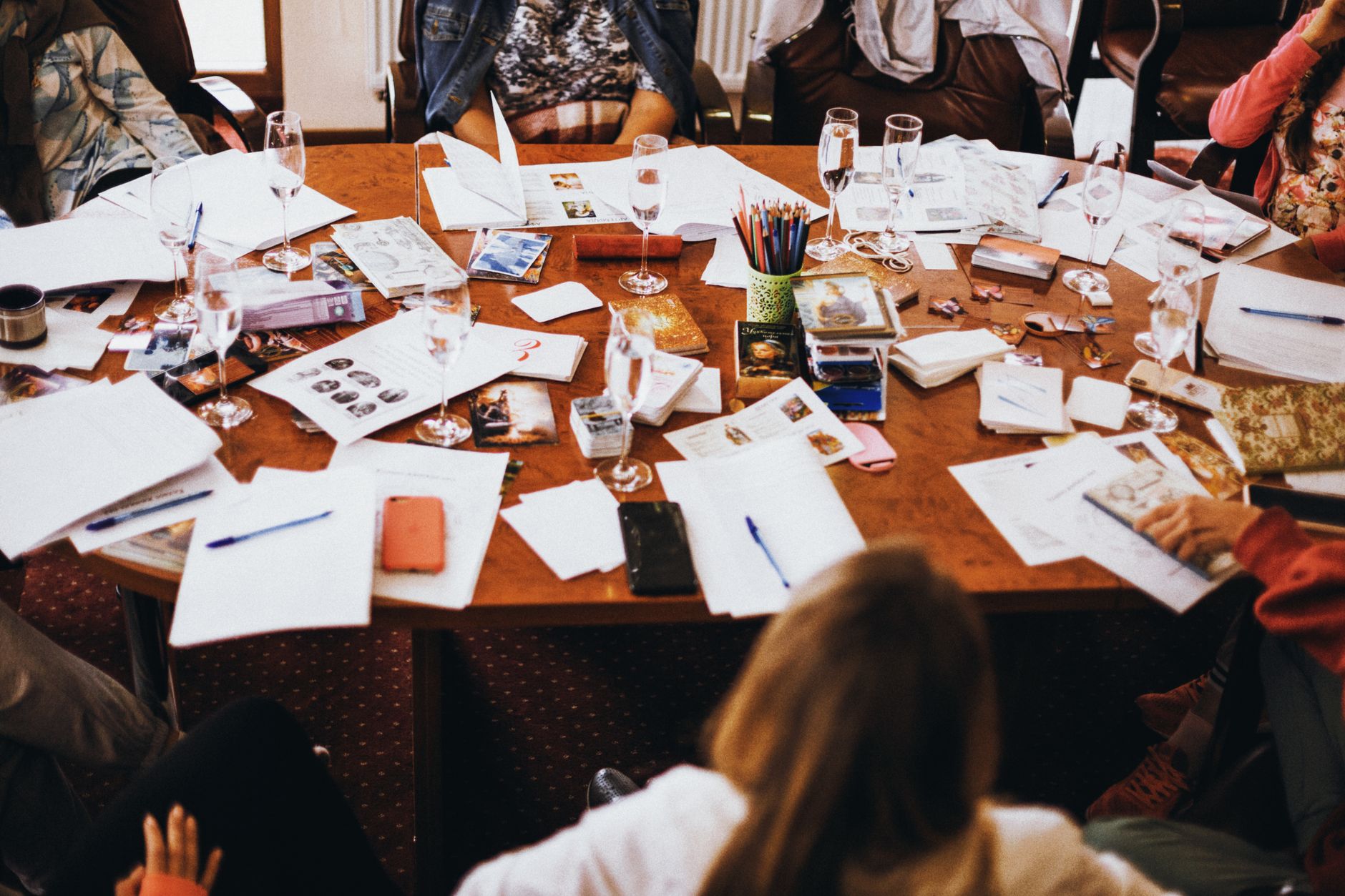 groupe collaborant autour d une table de conference en desordre remplie de documents et de boissons