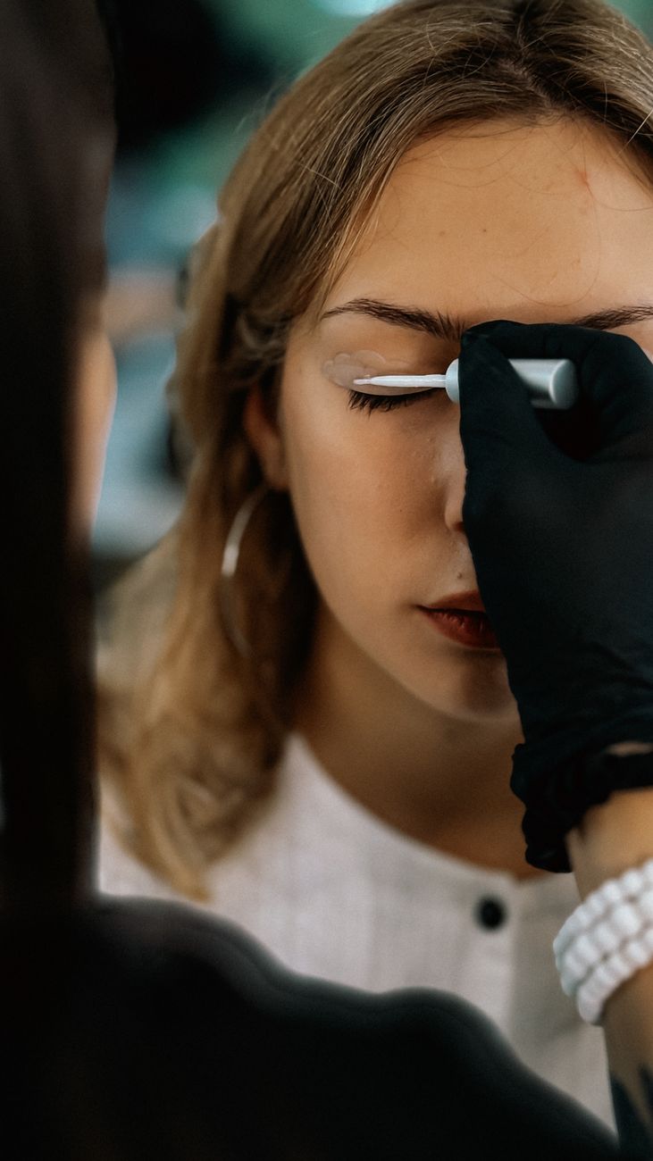 gros plan d un maquilleur appliquant du fard a paupieres sur une jeune femme dans un studio
