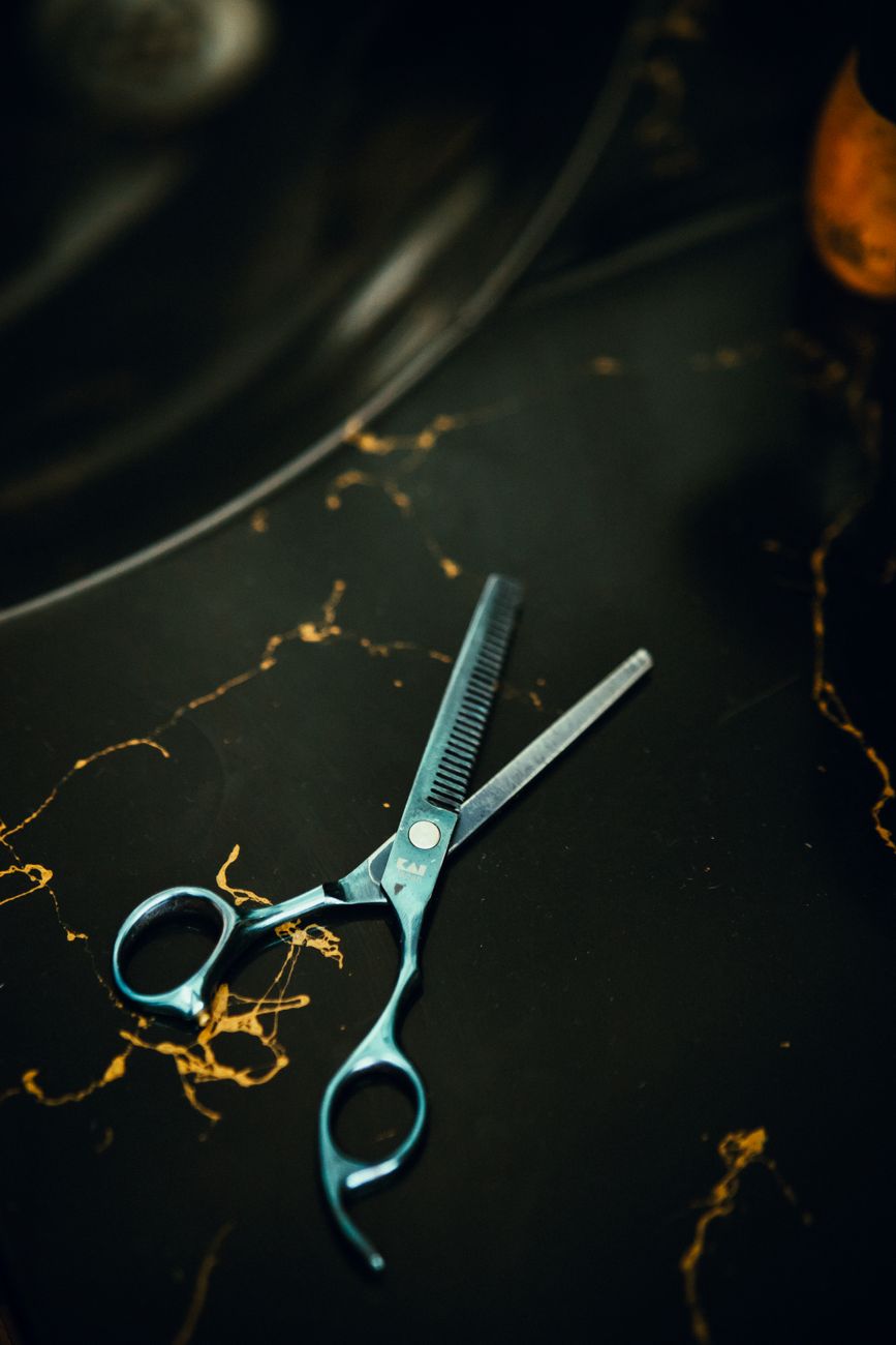 gros plan de ciseaux a effiler professionnels sur une surface en marbre noir parfait pour des themes de coiffure et de salon