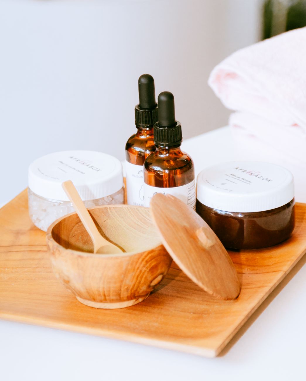 affichage esthetique de produits de soin naturel sur un plateau en bois avec des pipettes et des bocaux