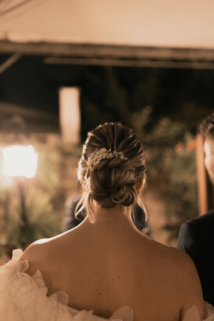 vue de dos d une mariee avec une coiffure elegante lors de sa reception de mariage la nuit