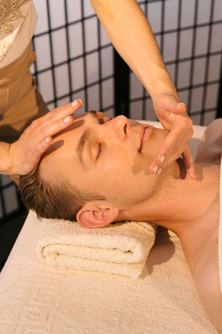 homme recevant un massage facial apaisant dans un spa professionnel mettant l accent sur la relaxation et le bien etre