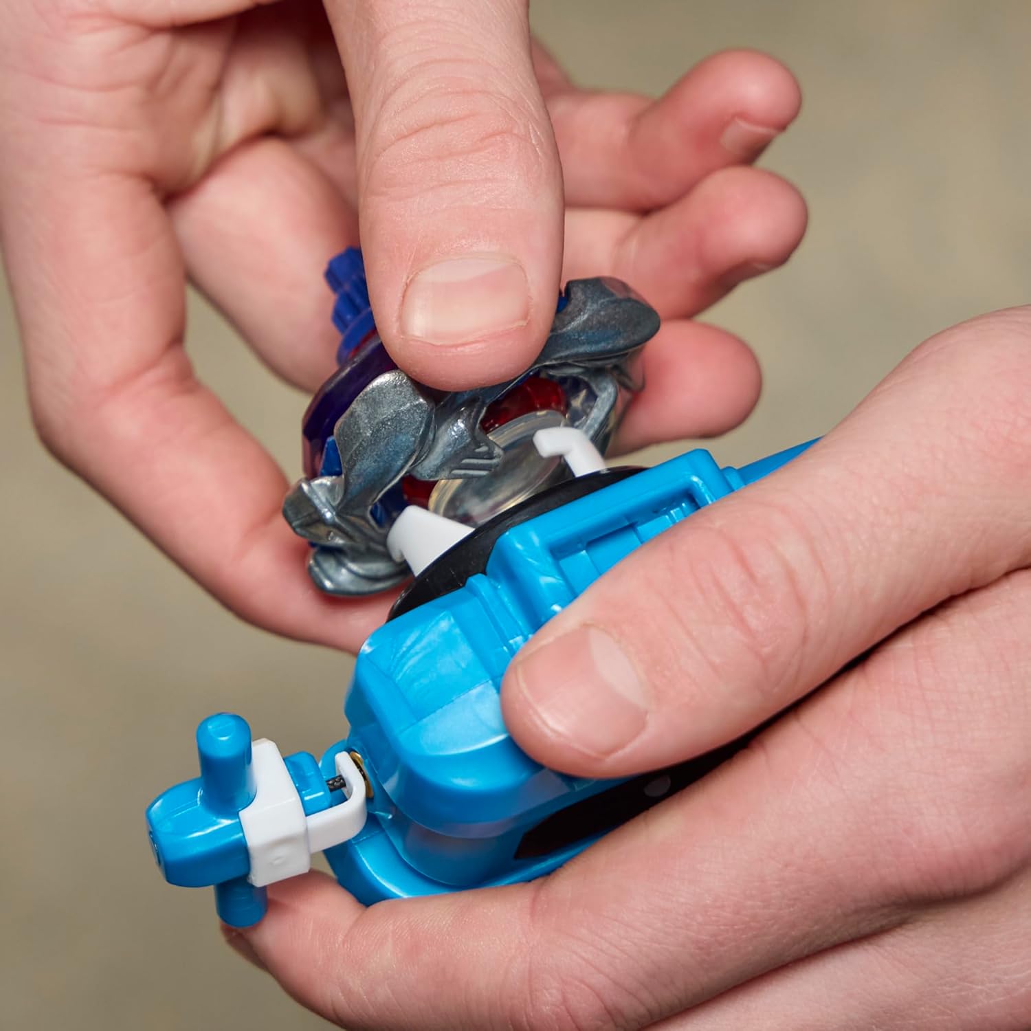 Mains qui fixent la toupie sur le lanceur à corde