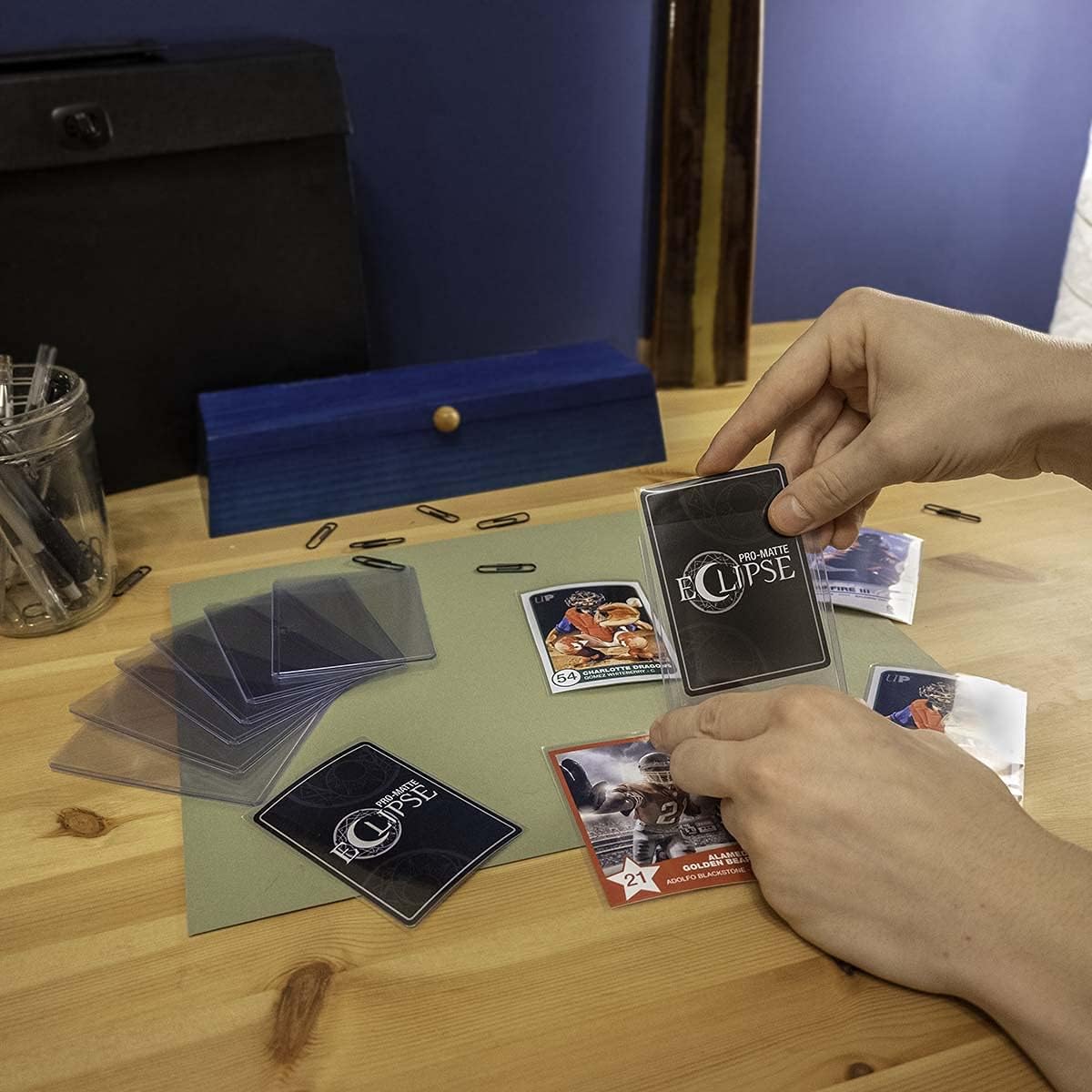 Carte glissée dans un toploader Ultra Pro sur un bureau