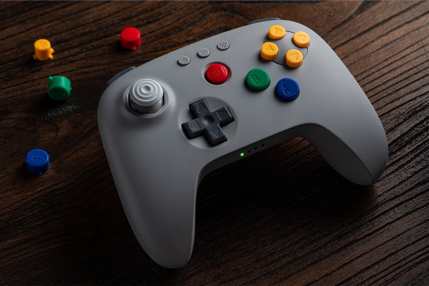 Manette 8BitDo 64 grise sur une table en bois