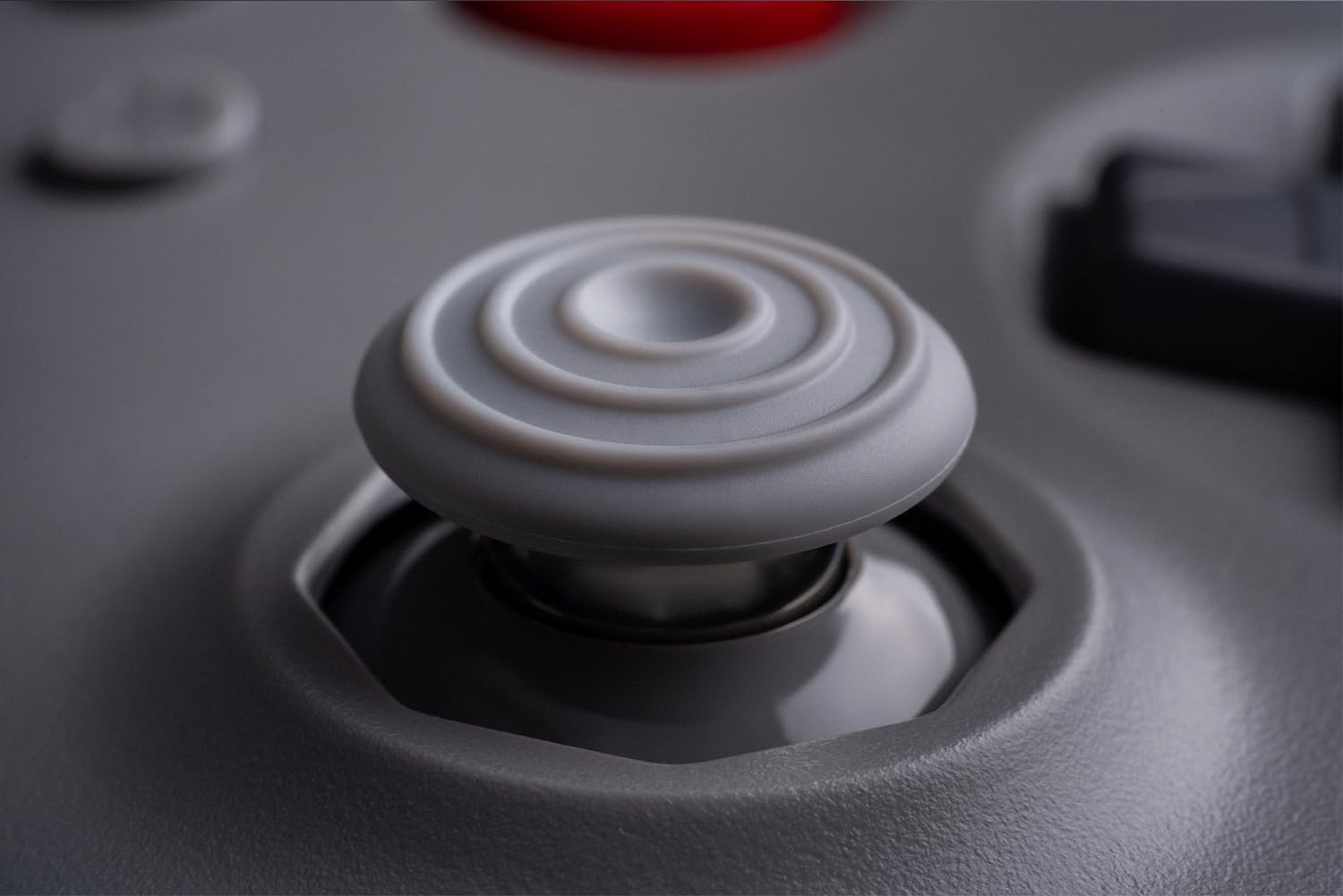 Gros plan du stick analogique gris de la manette 8BitDo 64