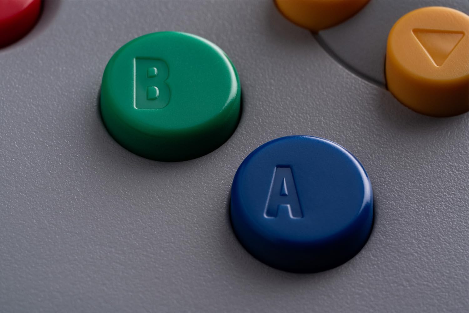 Gros plan des boutons A bleu et B vert de la manette 8BitDo 64