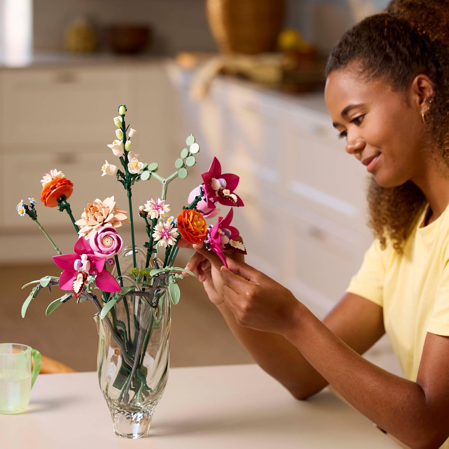 Jeune femme qui arrange le joli bouquet de fleurs roses LEGO