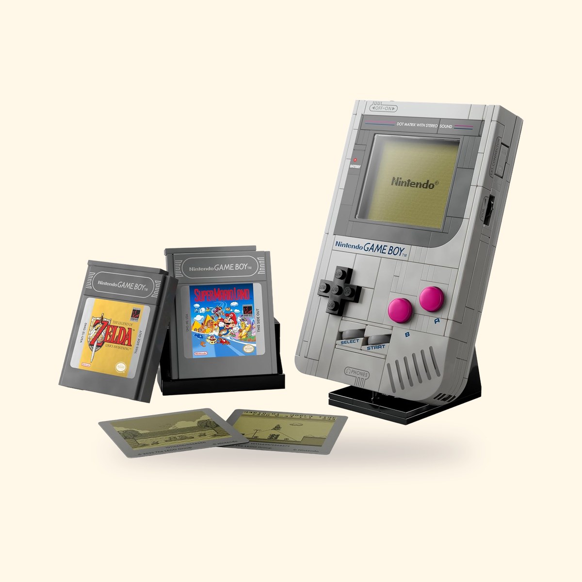 Set LEGO Game Boy 72046 monté sur son support, avec les cartouches Zelda et Super Mario Land, sur fond crème