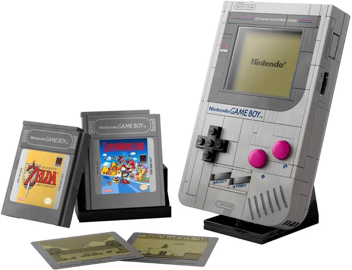 Game Boy LEGO sur son support, cartouches Zelda et Super Mario Land et deux écrans posés devant, sur fond blanc