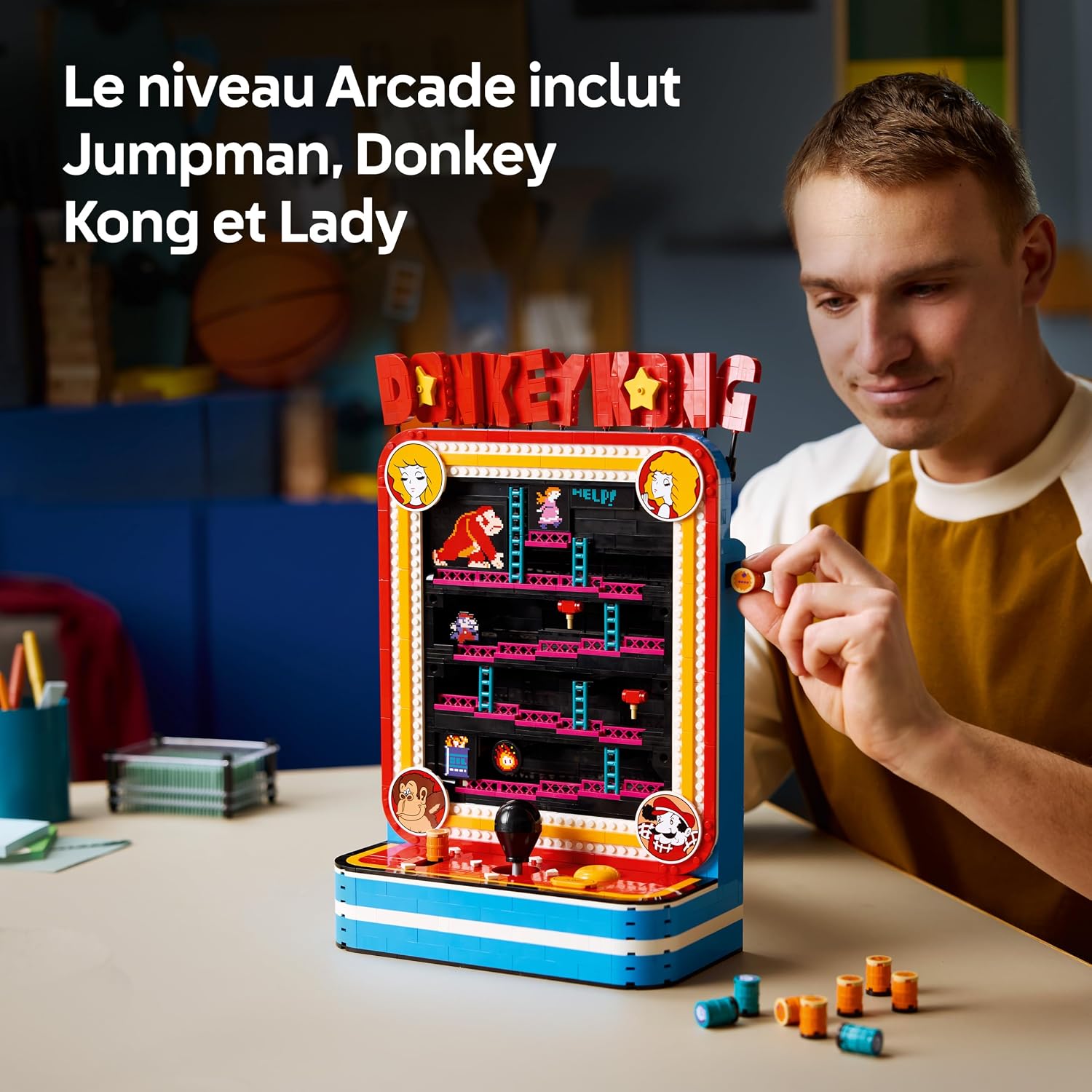 Homme qui regarde la borne LEGO Donkey Kong, un tonneau à la main, avec la mention Jumpman, Donkey Kong et Lady