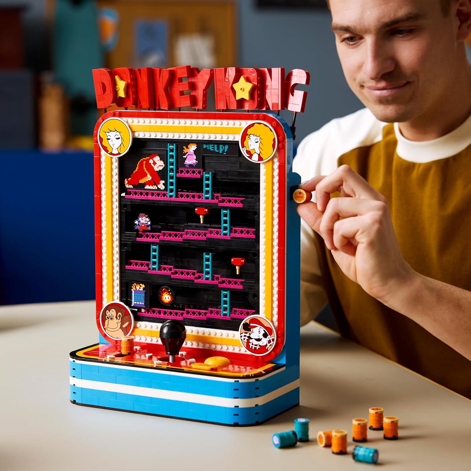 Homme qui glisse un tonneau dans la borne LEGO Donkey Kong posée sur une table