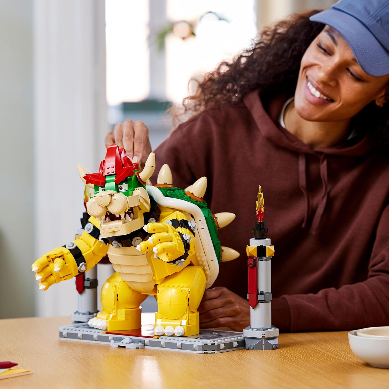Femme souriante derrière Bowser LEGO posé sur sa plateforme