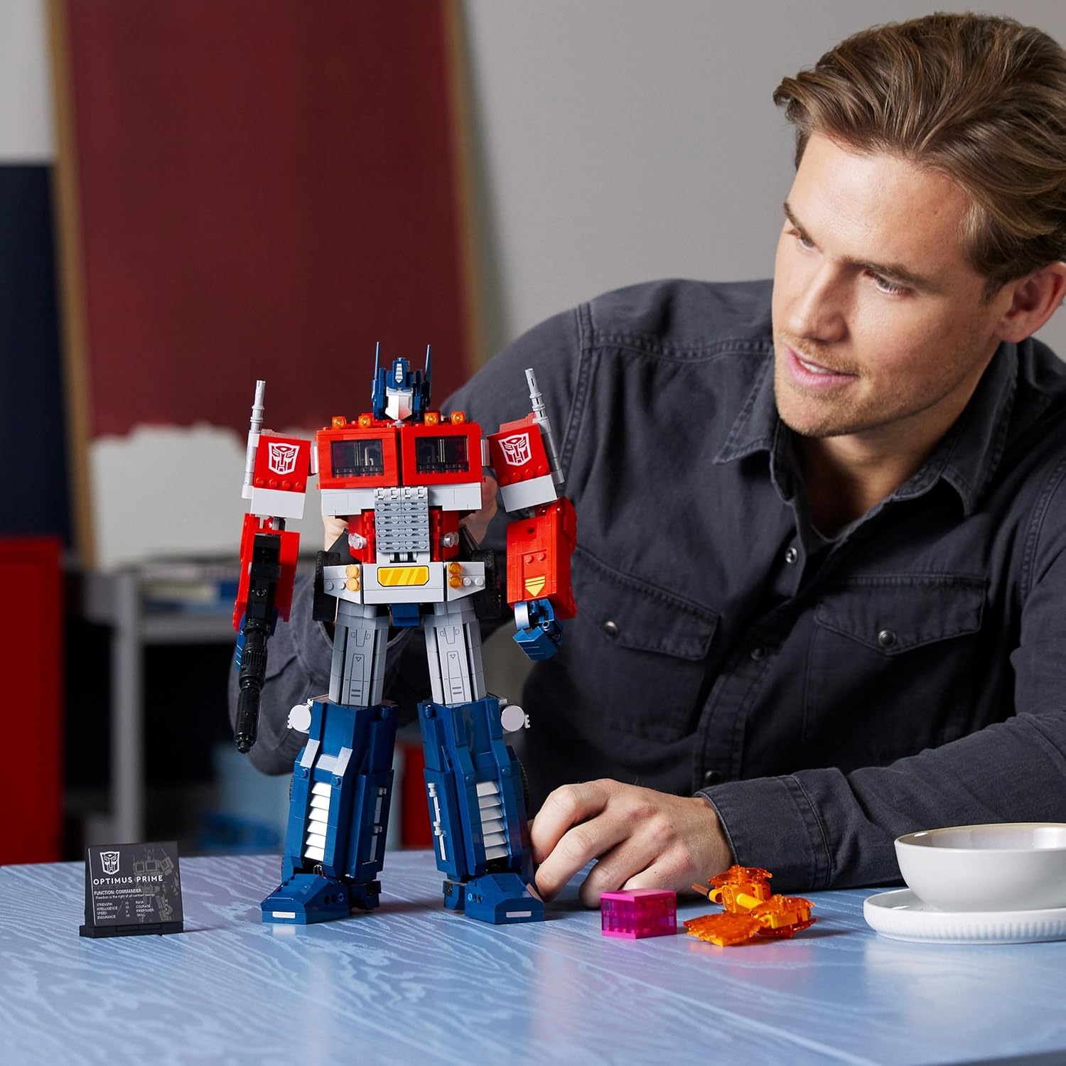 Homme qui regarde Optimus Prime en robot posé sur une table