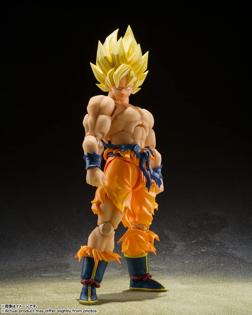 Goku debout de face, bras le long du corps, photographié sur fond sombre