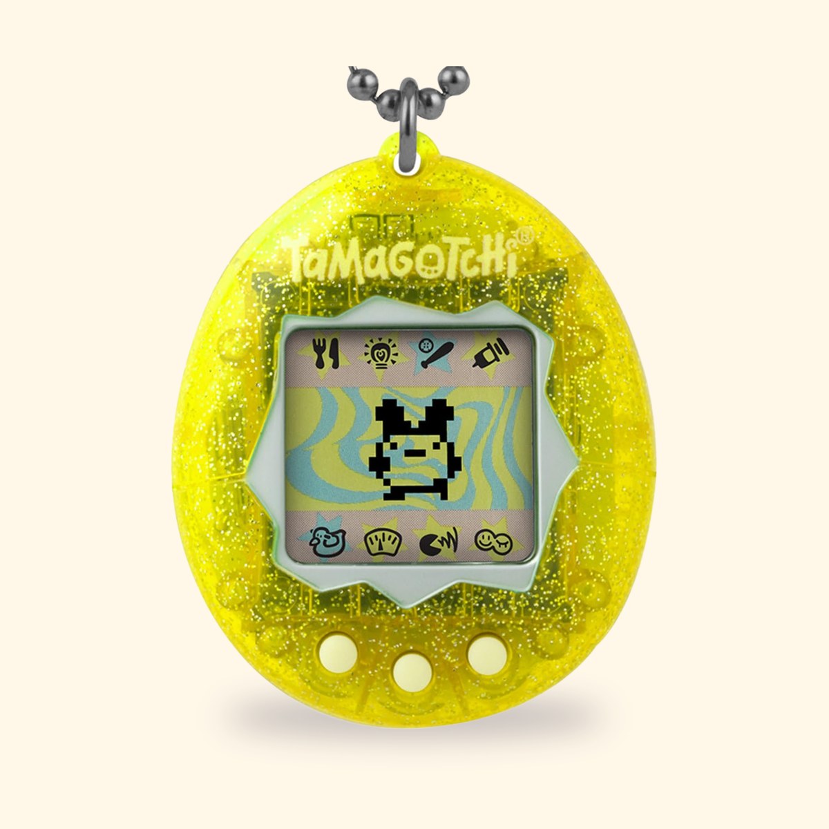 Tamagotchi Original Color Collection Yellow à coque jaune translucide et pailletée, sur fond crème