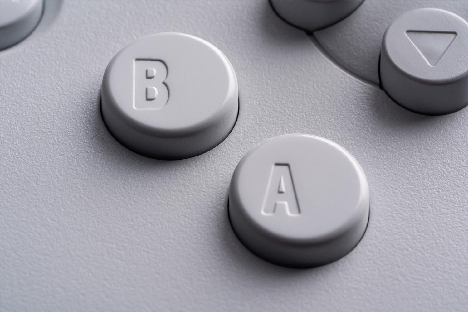 Gros plan des boutons A et B de la manette 8BitDo 64, version blanche