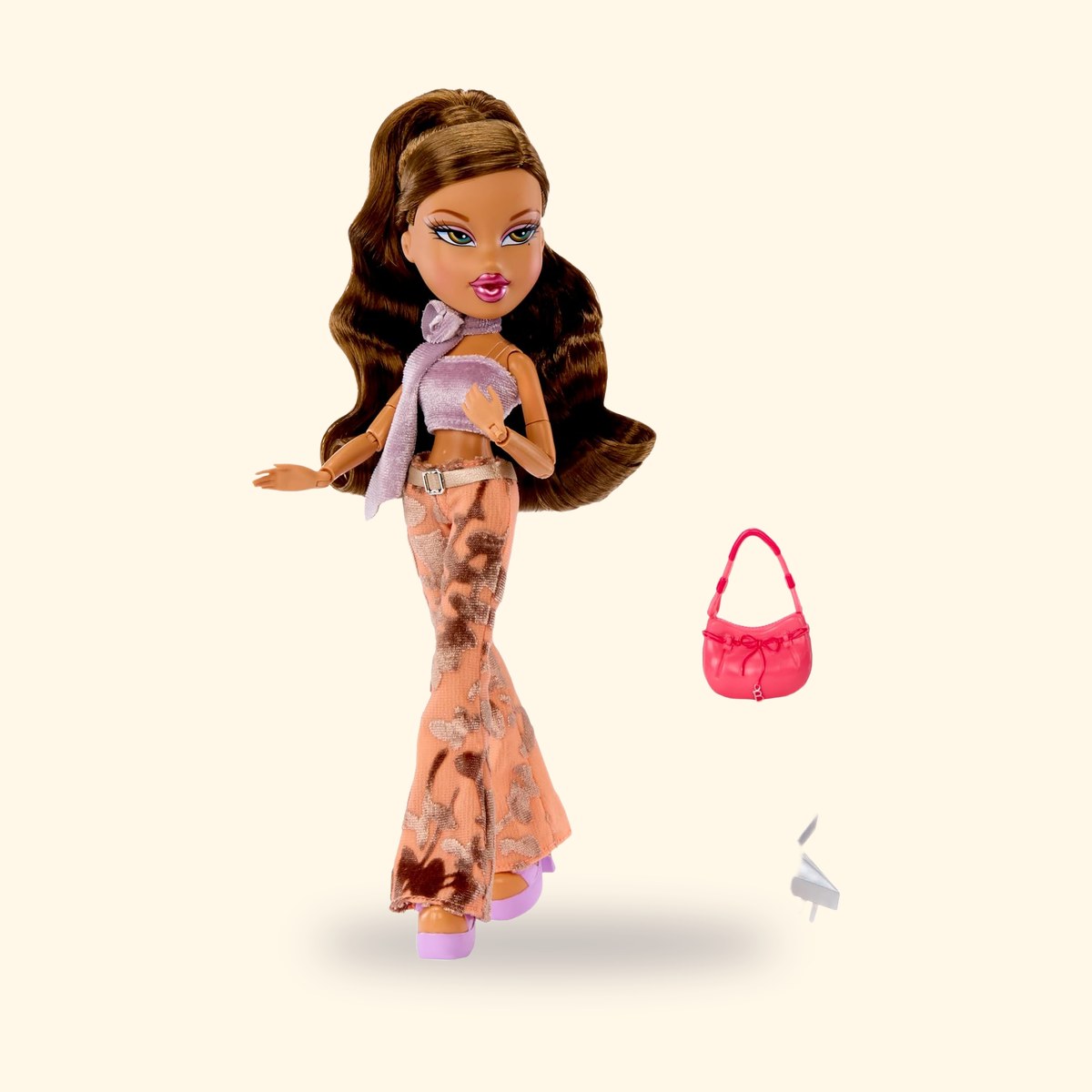 Poupée Bratz Yasmin en bustier lavande et pantalon évasé, avec ses accessoires, sur fond crème