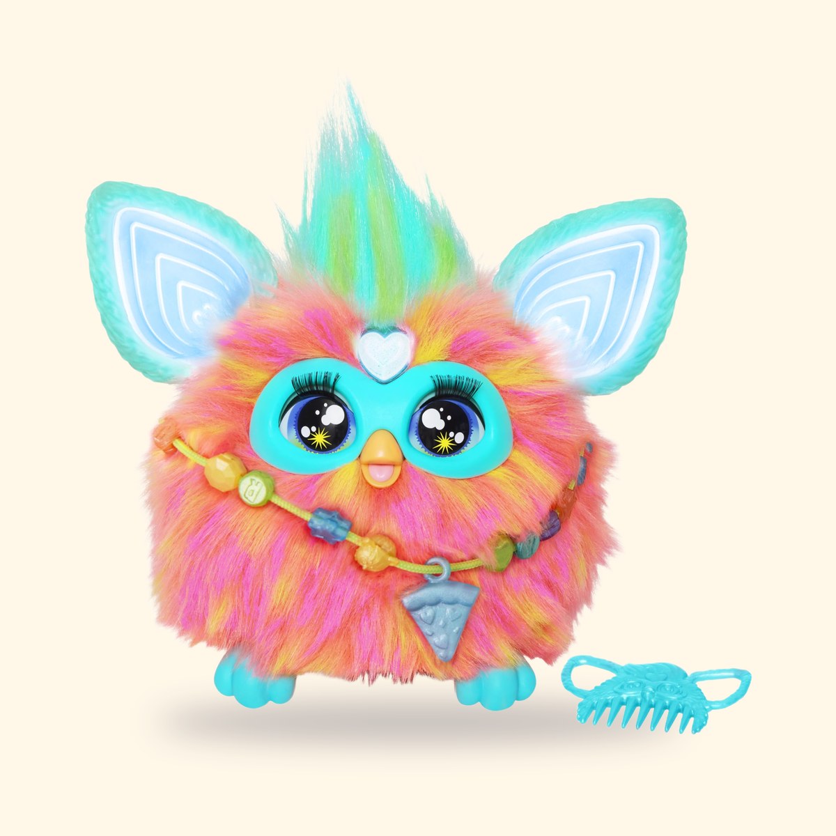 Furby Corail à fourrure rose orangé et oreilles turquoise, avec son collier de perles, sur fond crème
