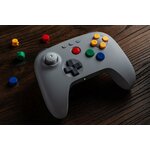 Manette 8BitDo 64 grise sur une table en bois