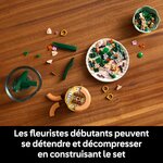 Pièces de lorchidée miniature LEGO triées dans des coupelles sur une table en bois