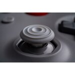 Gros plan du stick analogique gris de la manette 8BitDo 64