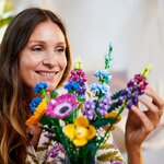 Femme souriante derrière le bouquet de fleurs sauvages LEGO