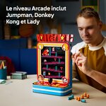 Homme qui regarde la borne LEGO Donkey Kong, un tonneau à la main, avec la mention Jumpman, Donkey Kong et Lady