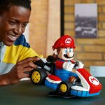 Homme souriant, la main sur le kart LEGO de Mario posé sur son support