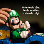 Gros plan sur une main qui oriente la tête de Luigi, avec un texte sur la tête, les bras et les mains