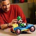Homme qui manipule le kart LEGO de Luigi posé sur son support