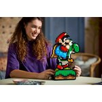 Femme souriante assise à côté du modèle LEGO Mario et Yoshi
