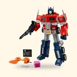 LEGO Icons Optimus Prime 10302 en mode robot avec son canon, ses accessoires et sa plaque, sur fond crème