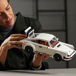 Femme qui tient la Porsche 911 Turbo LEGO devant elle