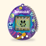 Tamagotchi Original Tama Universe à coque violette décorée de planètes et d'astronautes, sur fond crème
