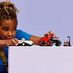 Enfant qui fait rouler les deux véhicules LEGO sur une table, le feu de départ à côté