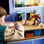 Enfant qui joue avec le set sur un bureau, le robot et les minifigurines posés devant lui