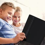 Deux enfants qui feuillettent le classeur noir Revspoir