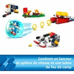 Sonic lancé dans sa sphère vers les robots, le lanceur et le feu de camp, légende en français