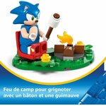 Gros plan sur Sonic assis près du feu de camp avec un bâton et une guimauve, légende en français