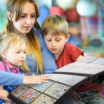 Femme et enfants qui regardent les cartes rangées dans un classeur