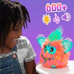 Enfant qui rit devant le Furby, visuel 600+ avec icônes de lumière, de musique et de son