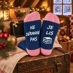 Chaussettes à message pour femme posées sur une malle dans un grenier de Noël