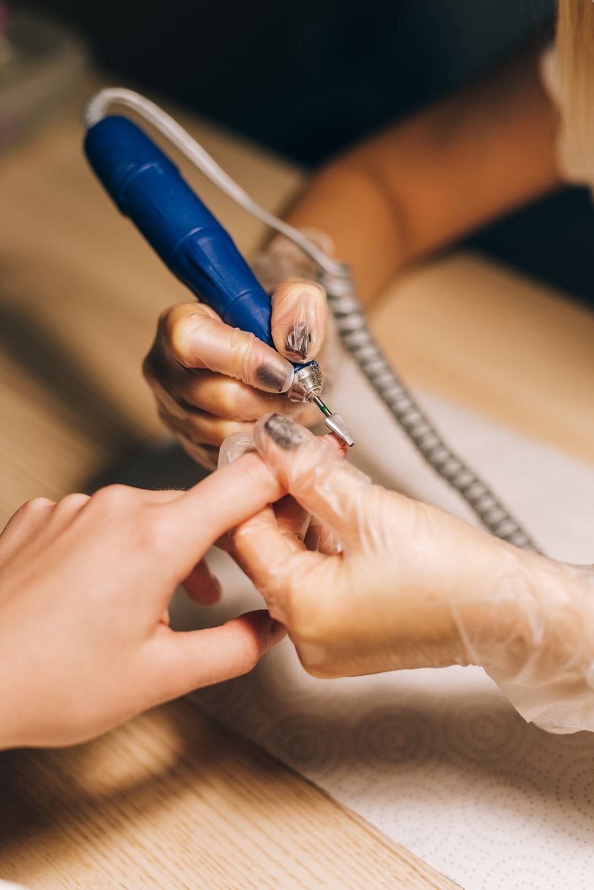 gros plan d une technicienne en onglerie utilisant une lime electrique lors d une seance de manucure ideal pour du contenu sur la beaute et la mo