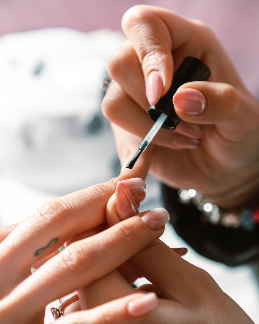 gros plan sur une manucure professionnelle avec application de vernis a ongles sous un eclairage lumineux