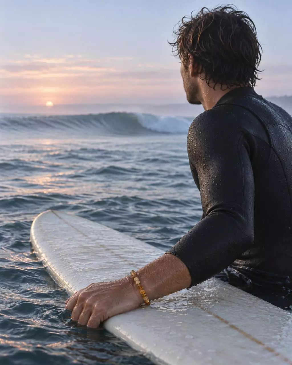 Surfeur au line-up au petit matin, bracelet en perles au poignet