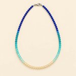 collier-en-perles-de-verre-bleu-ocean-et-sable-sur-fond-crem-2
