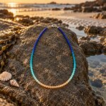 collier-en-perles-de-verre-bleu-ocean-pose-sur-un-rocher-a-m-2